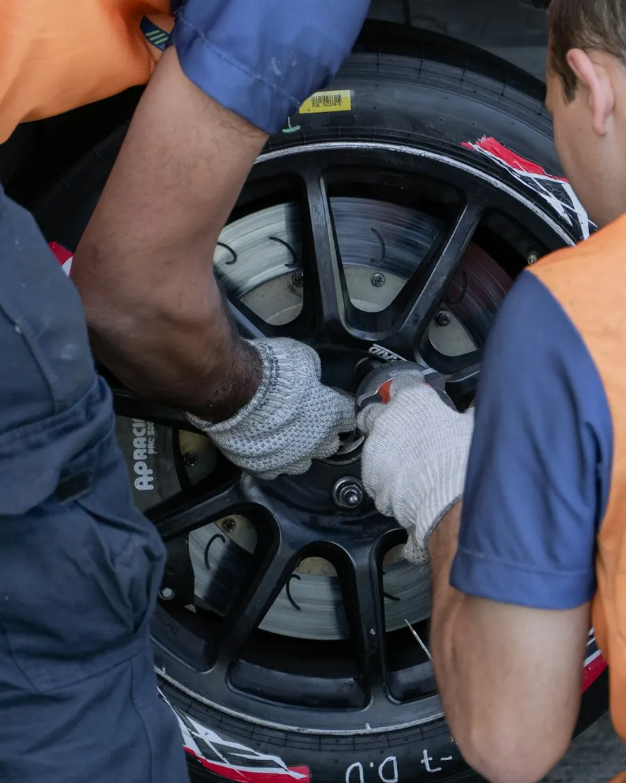 Two technicians working on a car wheel
